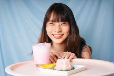 Pastel tatlı, pembe milkshake ve yapışkan pirinçli Asyalı kadın..