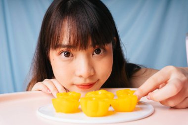 Genç Asyalı bir kadının tatlı altın keki yemesine yakından bakın..