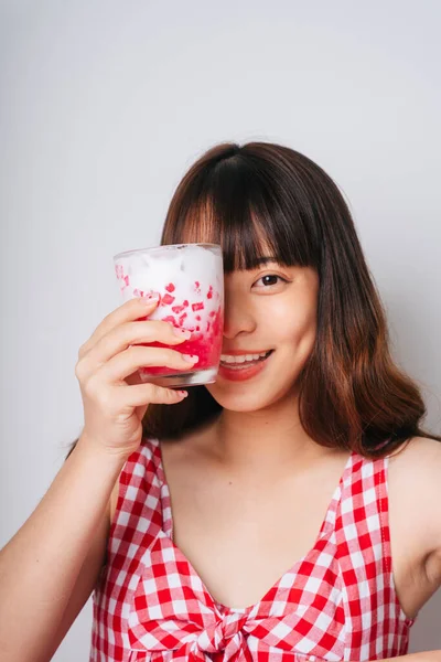 Elinde bir bardak tatlı su kestane tatlısı tutan Asyalı bir kadının portresi..