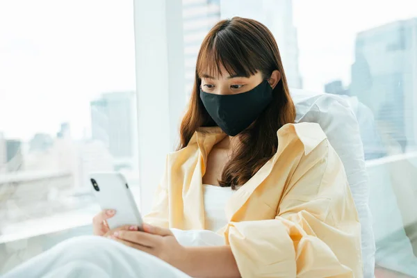 Young Asian Dark Hair Woman Wearing Mask Using Smartphone Bed — Stock Photo, Image