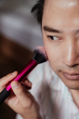 Asyalı eşcinsellerin önden görünüşü, yanağını pembe bir allıkla fırçalamaya odaklanmıştı..