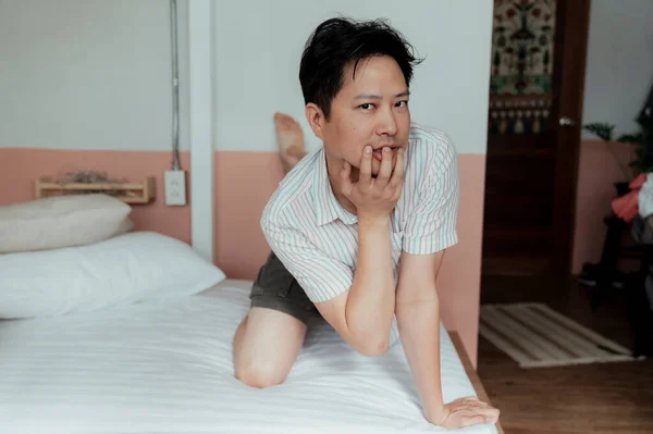猫のような奇妙な姿勢でベッドの上で裸のシャツでアジアのゲイの肖像写真 — ストック写真