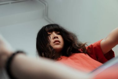 Taylandlı bir kız aynayı elinde tutar, gözleri boştur çünkü hayatının anlamını bulamaz..