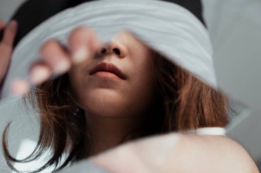 Elindeki bir ayna parçasında bir kızın ağzının yansıması..