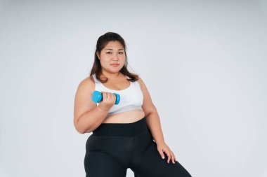 Beyaz arka planda mavi dambıl kullanan Asyalı tombul kadın..