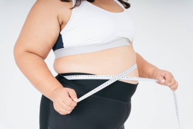 Beyaz spor sutyen ve mezura takan sağlıklı Asyalı tombul kadın. Zayıflamış konsept.