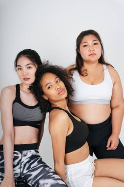 Beyaz arka planda Asyalı ve Afrikalı üç farklı kadın grubu..