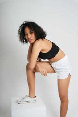 Beyaz arka planda siyah spor sutyen giyen Afro ırk portresi ve Taylandlı kadın..