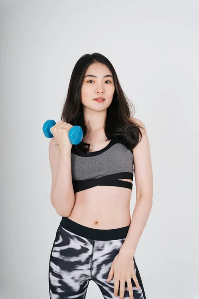 身穿灰色运动胸罩运动 背景为白色的哑铃的亚洲美女 — 图库照片