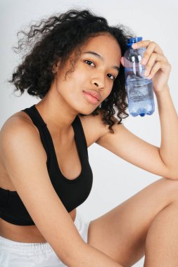 Bir şişe su tutan Afrikalı ve Taylandlı kadının portresi..