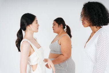 Beyaz arka plan üzerinde Asyalı ve Afrikalı kadınların etnik çeşitliliğinin portresi.