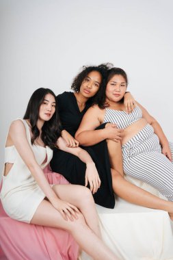 Beyaz arka planda Afrikalı ve Taylandlı kadınların grup portresi.