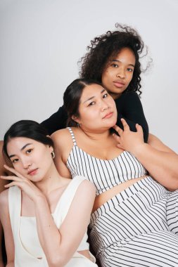 Beyaz arka planda Afrikalı ve Taylandlı kadınların grup portresi.