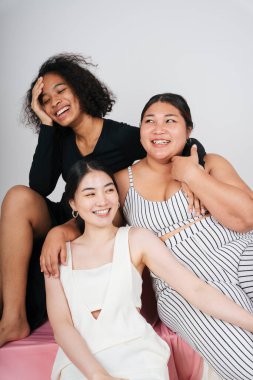 Beyaz arka planda Afrikalı ve Taylandlı kadınların grup portresi.