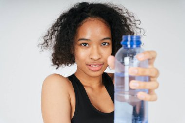 Beyaz arka planda plastik su şişesi tutan Afrikalıların portresini kapat. 