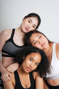 Beyaz arka planda Asyalı ve Afrikalı üç farklı kadın grubu..
