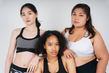 Beyaz arka planda Asyalı ve Afrikalı üç farklı kadın grubu..