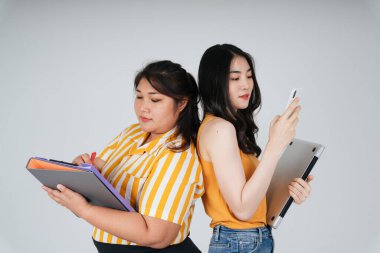 Farklı boyutlarda iki Asyalı iş kadını. Şişman ve zayıf çalışan kızlar..