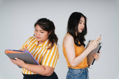 Farklı boyutlarda iki Asyalı iş kadını. Şişman ve zayıf çalışan kızlar..