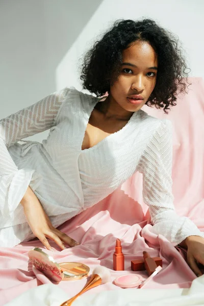 Kozmetik ürünleri olan melez Afrikalı ve Taylandlı kadın portresi.