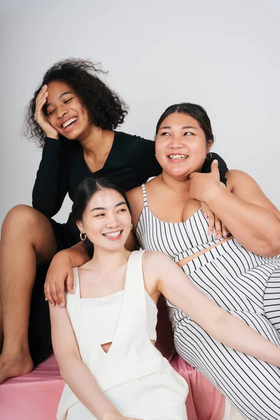 Beyaz arka planda Afrikalı ve Taylandlı kadınların grup portresi.