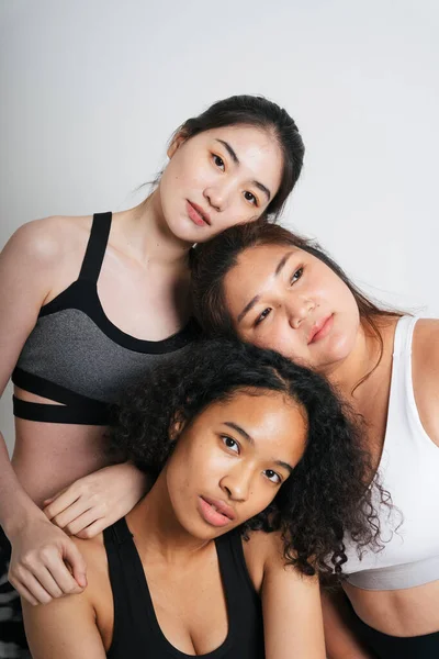 Beyaz arka planda Asyalı ve Afrikalı üç farklı kadın grubu..