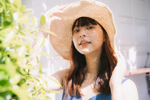 亚洲年轻女旅行家在院子里穿着蓝色衣服 头戴蓝色帽子的画像 — 图库照片