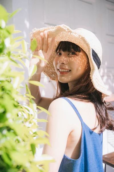 亚洲年轻女旅行家在院子里穿着蓝色衣服 头戴蓝色帽子的画像 — 图库照片
