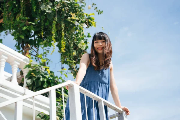 在阳光明媚的日子 年轻的亚洲女人穿着蓝色的衣服在阳台上旅行 — 图库照片