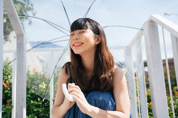 在阳光明媚的日子 身穿蓝色衣服 手持透明雨伞的年轻亚洲女性旅行者 — 图库照片