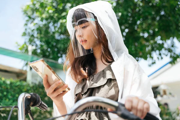Young Asian Woman Wearing White Raincoat Face Shield Using Smartphone — Stock Photo, Image