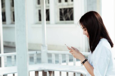 Üniversitenin arkadaşıyla sohbet ederken gülümseyen bir kız..