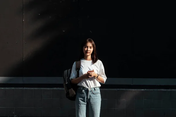 Gadis Thailand Berdiri Depan Dinding Memegang Smartphone Melihat Langsung Kamera — Stok Foto