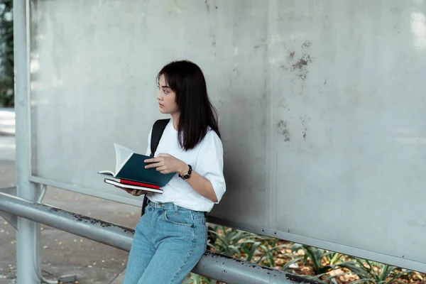 Uma Menina Lendo Livro Enquanto Ela Espera Ônibus Parada Ônibus — Fotografia de Stock