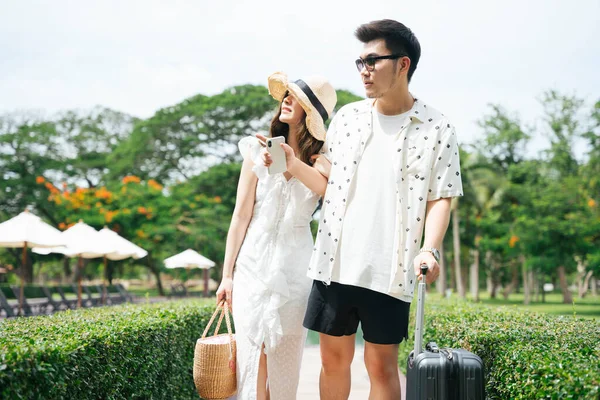 Asian couple traveler walking in the park looking for a room.