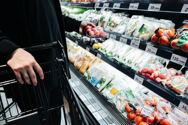 Клиент покупает овощи с полки магазинов
.