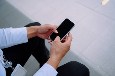 Sokakta akıllı telefon kullanan iş adamının elini kapat..