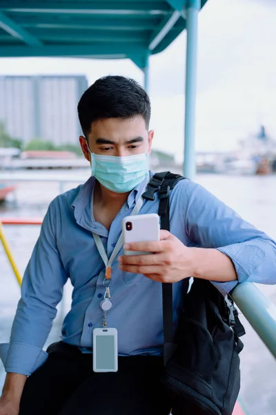 Ασιάτης Επιχειρηματίας Φορούν Μάσκα Χρησιμοποιώντας Smartphone Στην Προβλήτα Περιμένει Για — Φωτογραφία Αρχείου