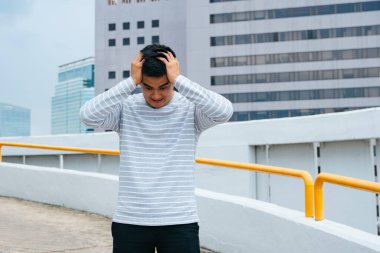 Mutsuz adam elleriyle başını sıkıyor, baş ağrısı çekiyor..