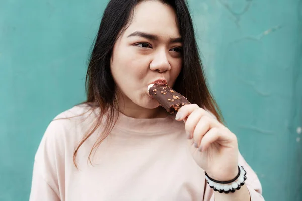 Kvinna Äter Choklad Glass Framför Grön Vägg — Stockfoto