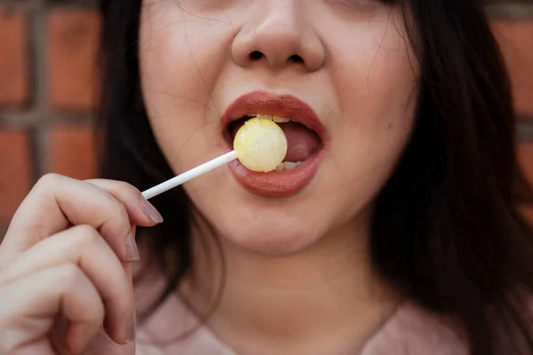 Menutup Tembakan Mulut Wanita Sementara Dia Makan Lolipop Kuning — Stok Foto