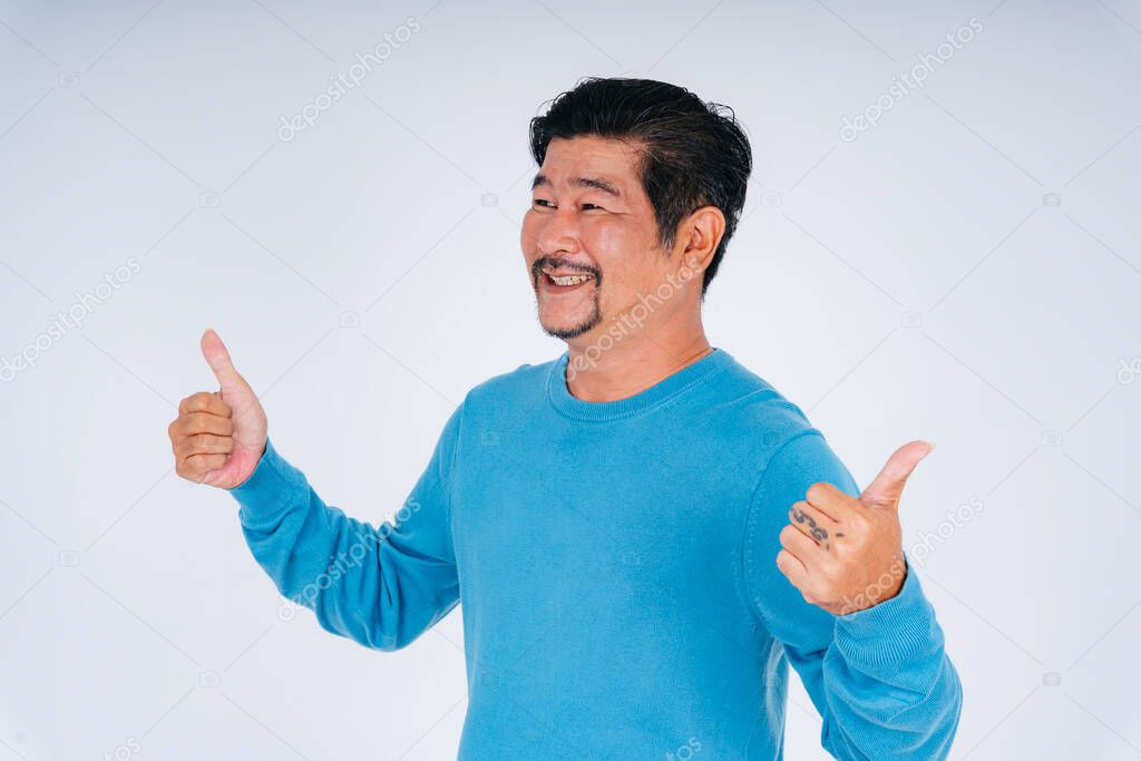 Portrait of old elderly senior man in blue long sleeve shirt thumbs up gesture.