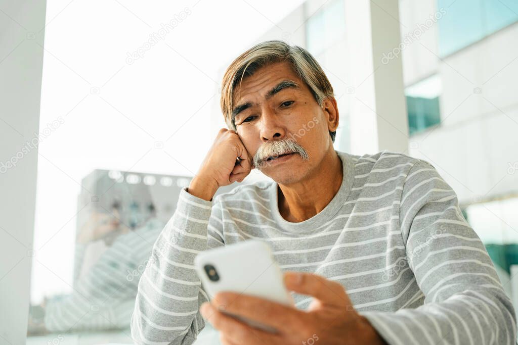Old senior man using smartphone surf the internet.