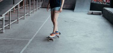 Kaykay yolunda kaykay sürerken kadın bacaklarının kesilmiş görüntüsü..