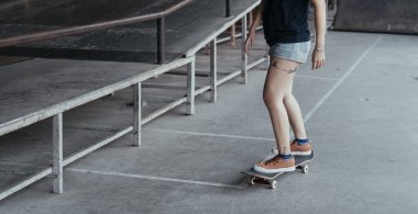 Kaykay yolunda kaykay sürerken kadın bacaklarının kesilmiş görüntüsü..