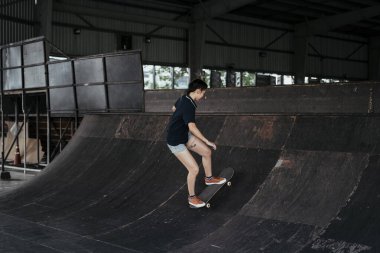 Boş zamanlarında paslı virajda uzun panoya binen şortlu kadın..