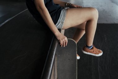 Ahşap bankta oturup, uzun tahtayı tutarken bir kadının bacakları kesilmiş..