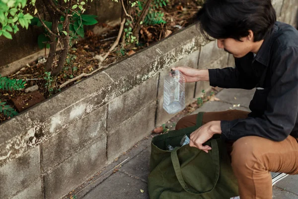 Ein Mann Schwarzen Hemd Sammelt Mit Seiner Stofftasche Die Plastikflasche — Stockfoto
