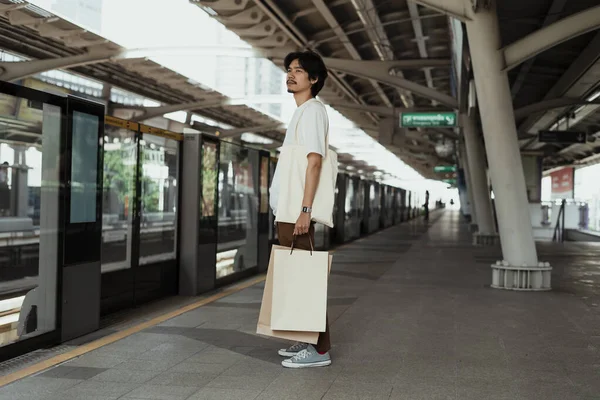 Beyaz Tişörtlü Bir Adam Kağıt Alışveriş Çantasını Tutarak Trenin Eve — Stok fotoğraf