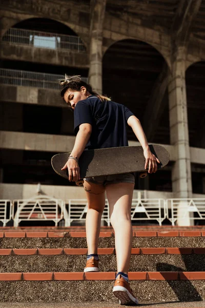어두운 셔츠를 여성이 콜로세움으로 보드를 조약돌 계단을 오릅니다 — 스톡 사진